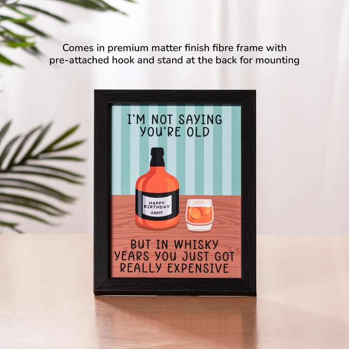 Aged To Perfection Whiskey Birthday Frame in a premium matte finish fibre frame with pre-attached hook and stand for wall and desk mounting, displaying the whiskey birthday illustration in a home setting