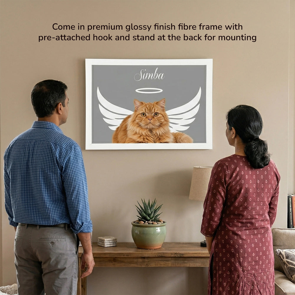 Angel Wings Memorial Personalized Pet Frame shown on a wall in a living room setting, featuring an orange cat named Simba with white angel wings, with a couple viewing it from behind