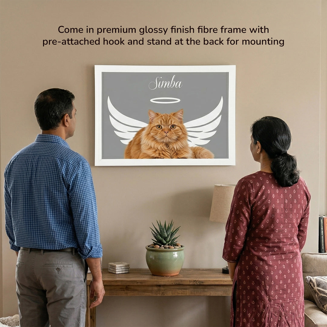 Angel Wings Memorial Personalized Pet Frame shown on a wall in a living room setting, featuring an orange cat named Simba with white angel wings, with a couple viewing it from behind