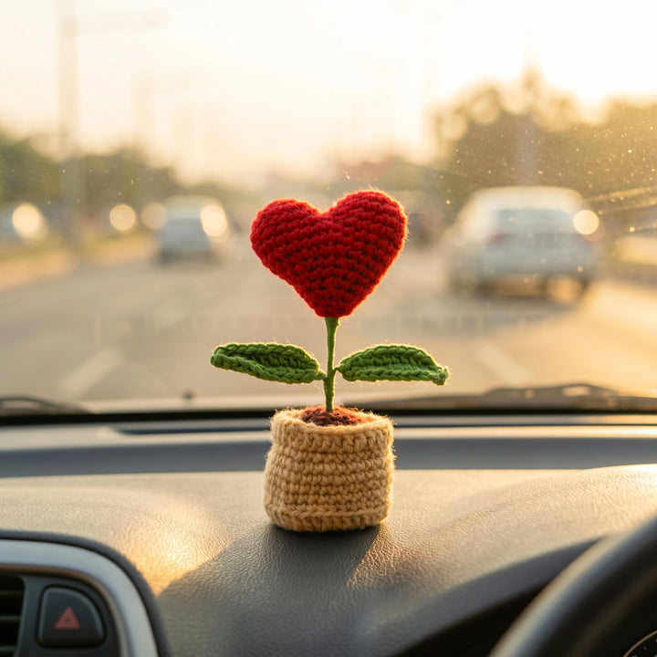 Crocheted heart-shaped plant on a car dashboard 