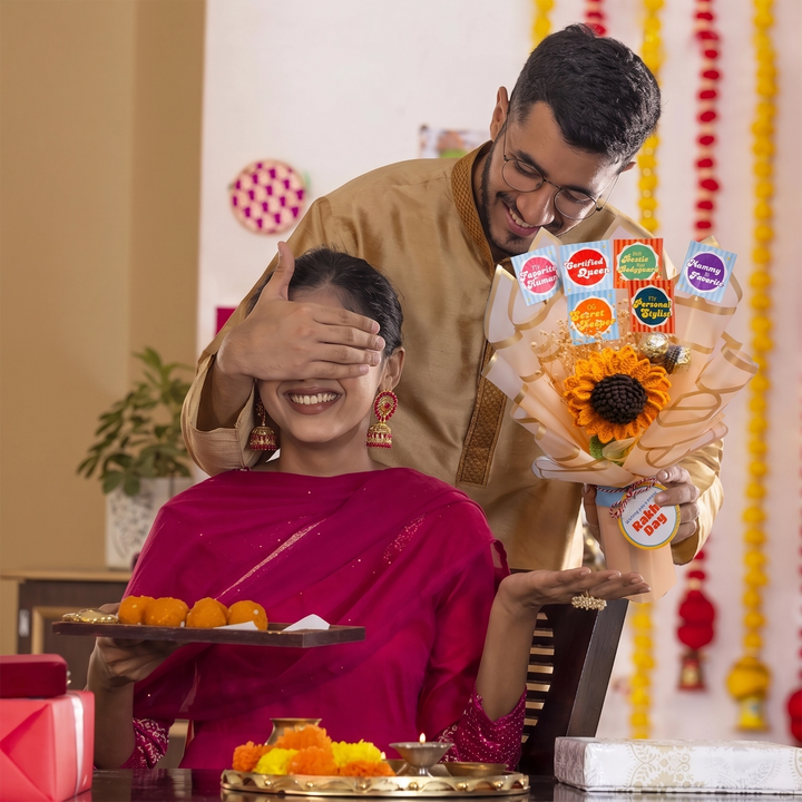 Man covering woman's eyes with a sugar sunflower sass rakhi bouquet crochet handmade gift india